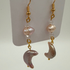 Pair of earrings with pink and clear beads on a white card