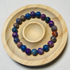Colorful beaded bracelet on a wooden plate with a white background