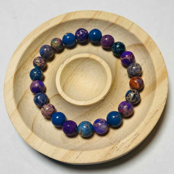 Colorful beaded bracelet on a wooden plate with a white background