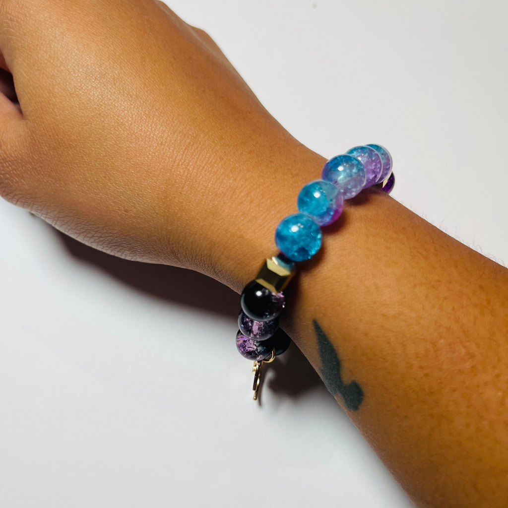 Hand wearing a colorful beaded bracelet on a white background