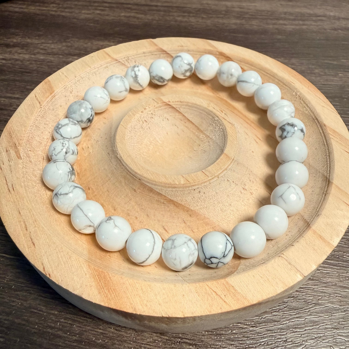 White beaded bracelet on a wooden coaster