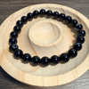 Black beaded bracelet on a wooden surface