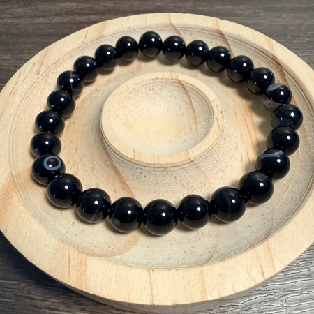 Black beaded bracelet on a wooden surface